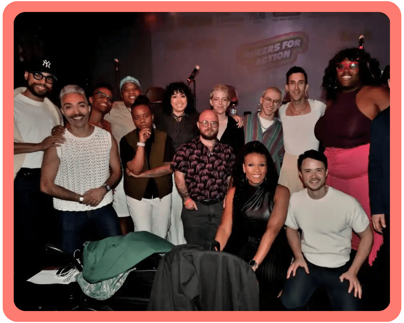 A large group of diverse queer people smiling for a photo at the Queers for Action Pride Kick Off Mayoral Forum