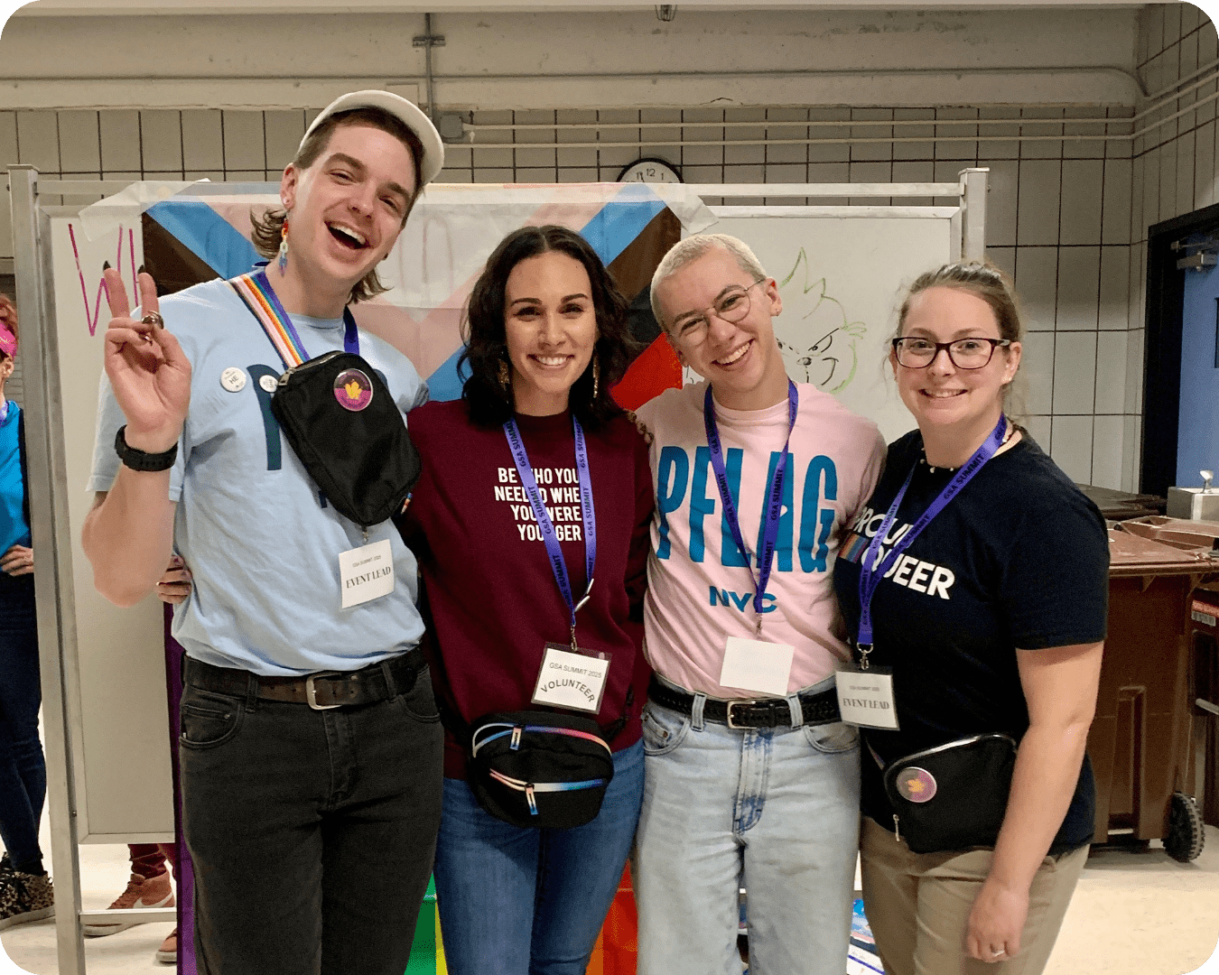 Four PFLAG NYC staff members smiling with their arms around each other