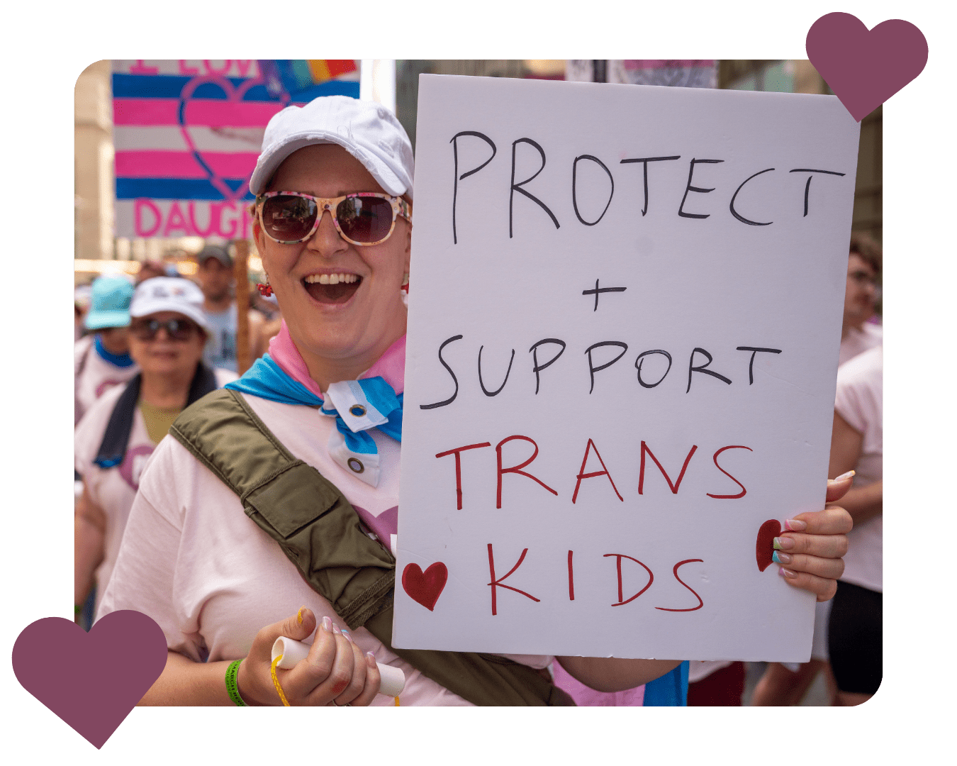 A PFLAG NYC parent holds up a sign at the NYC Pride March that reads, "Protect and support trans kids."