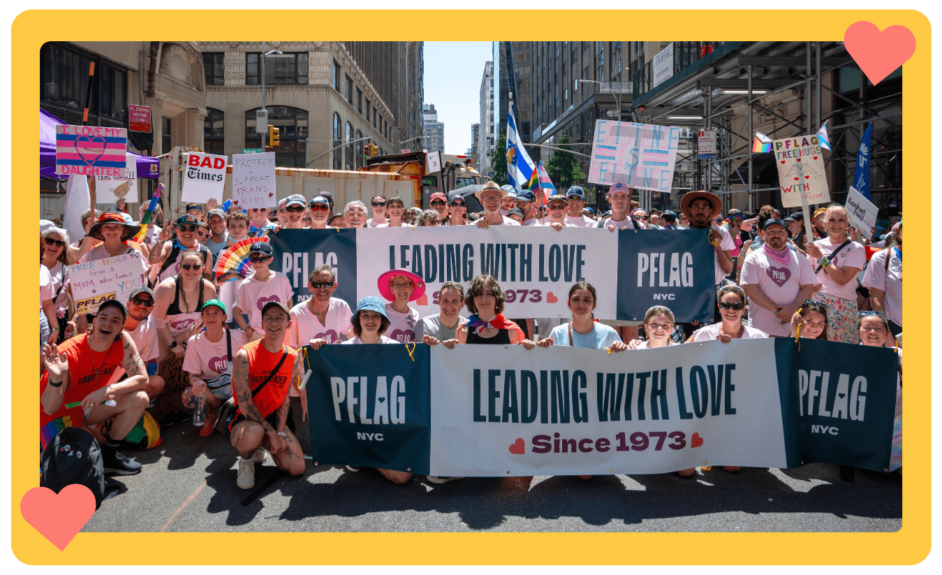 A photo of a large group of diverse people of different ages holding up banners and signs and wearing PFLAG NYC shirts at the 2025 NYC Pride March